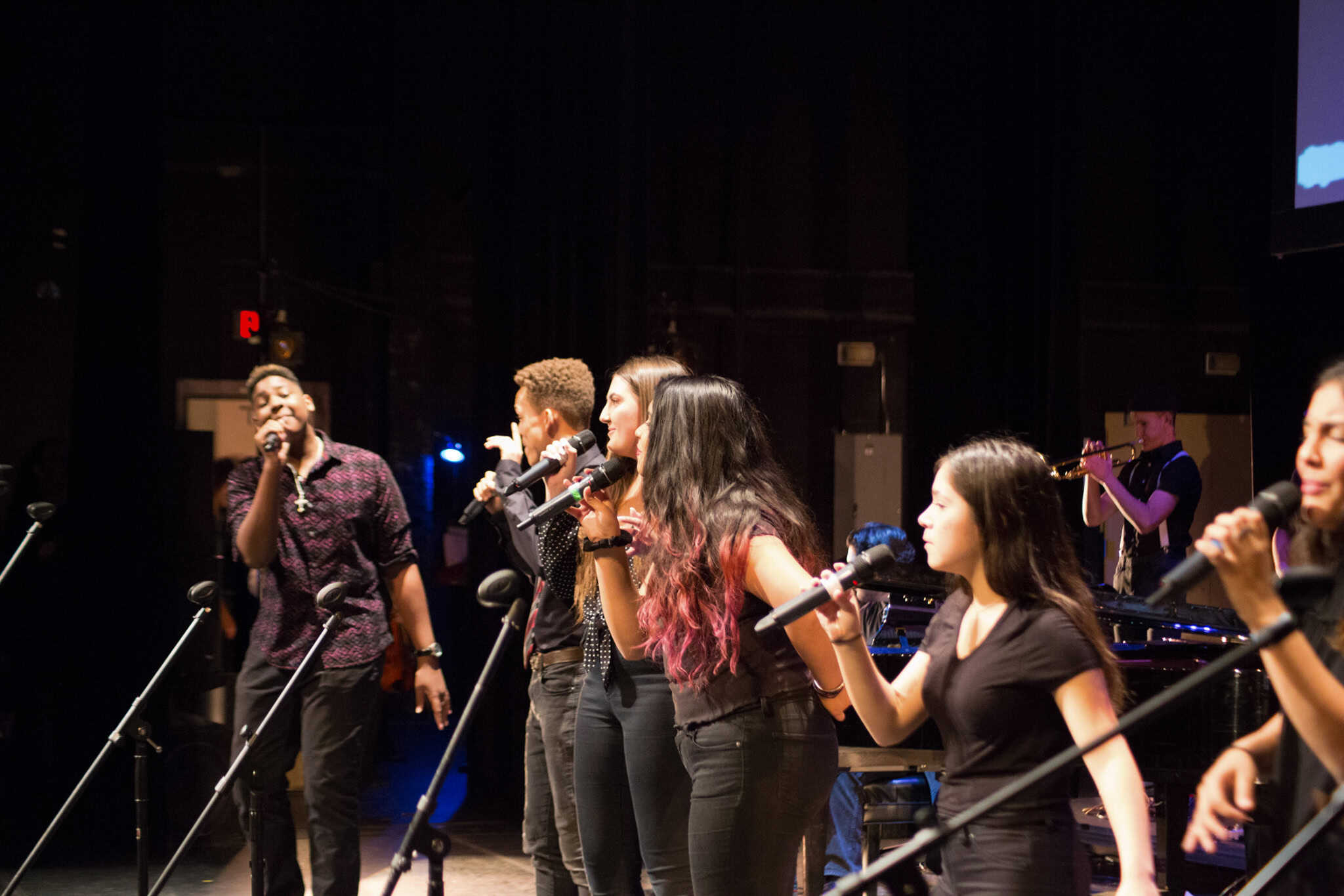 Six Phoenix Conservatory of Music students in their teens, singing on stage during a performing.