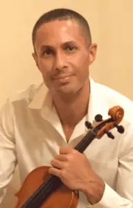 Photo of musician, violinist and teacher Mohamed-Aly Farag, holding a violin.