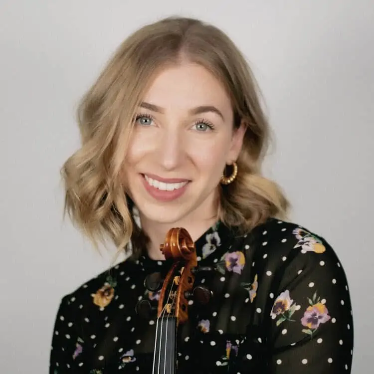 Violinist and teacher Meghan Ruel holding a violin.